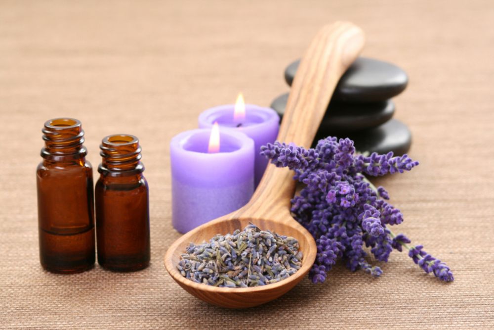 Aromatherapeutische Mischungen ätherischer Öle in Schalen mit Blumen