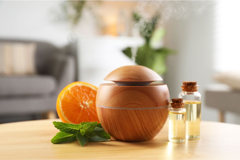 Holz-Aroma-Diffuser mit ätherischen Ölen, Minze und Orange in einem gemütlichen Wohnambiente.