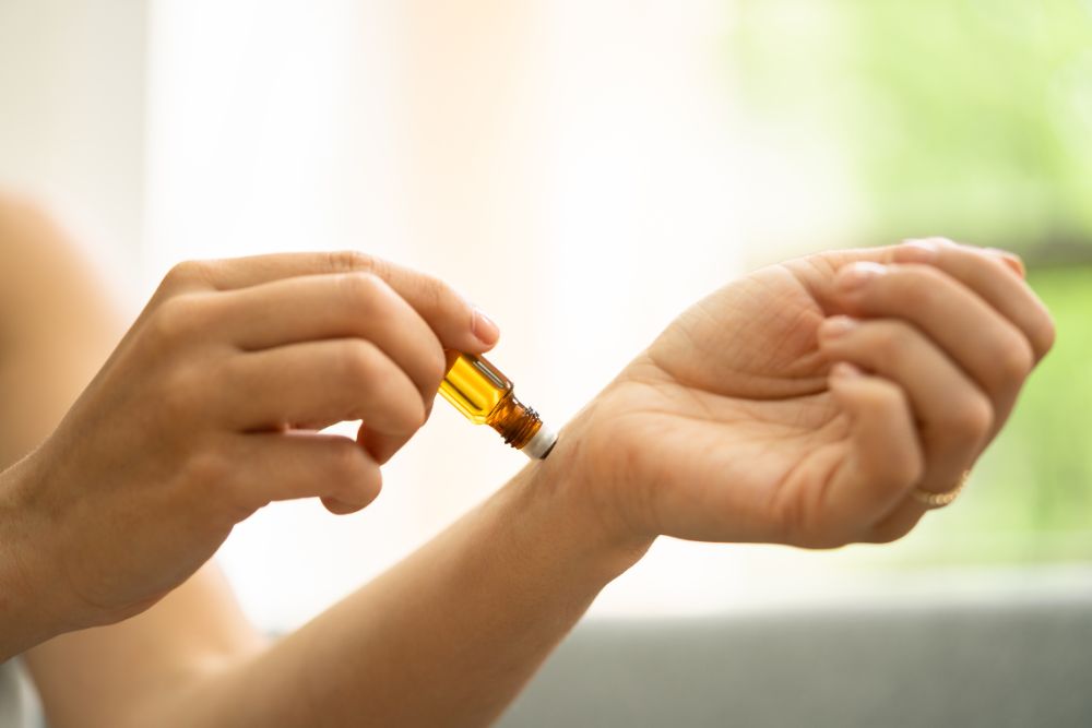 Auftragen von ätherischem Öl auf das Handgelenk – Beispiel für sichere Anwendung der Aromatherapie im häuslichen Umfeld.