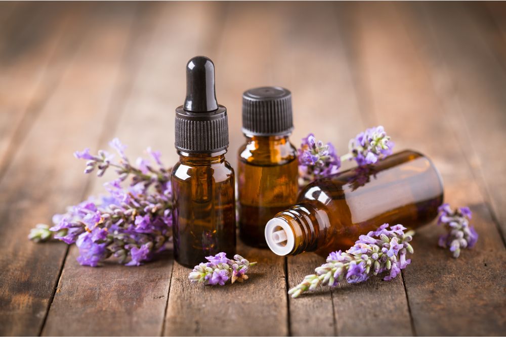 Fläschchen mit Lavendel-Essenzöl und Lavendelblüten auf einem Holztisch – Naturkosmetik.